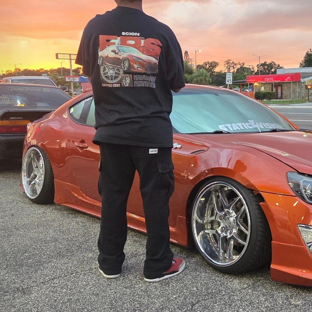Customer wearing our custom car T-shirt featuring their Scion FRS, photographed next to their car.