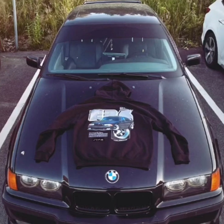 Customer wearing our custom car Hoodie featuring their Bmw E36, photographed next to their car.
