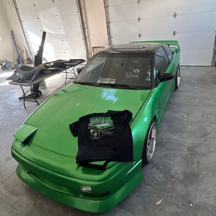 Customer wearing our custom car T-shirt featuring their Nissan 240sx, photographed next to their car.