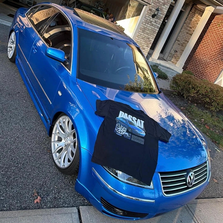 Customer wearing our custom car T-shirt featuring their Volkwagen Passat, photographed next to their car.