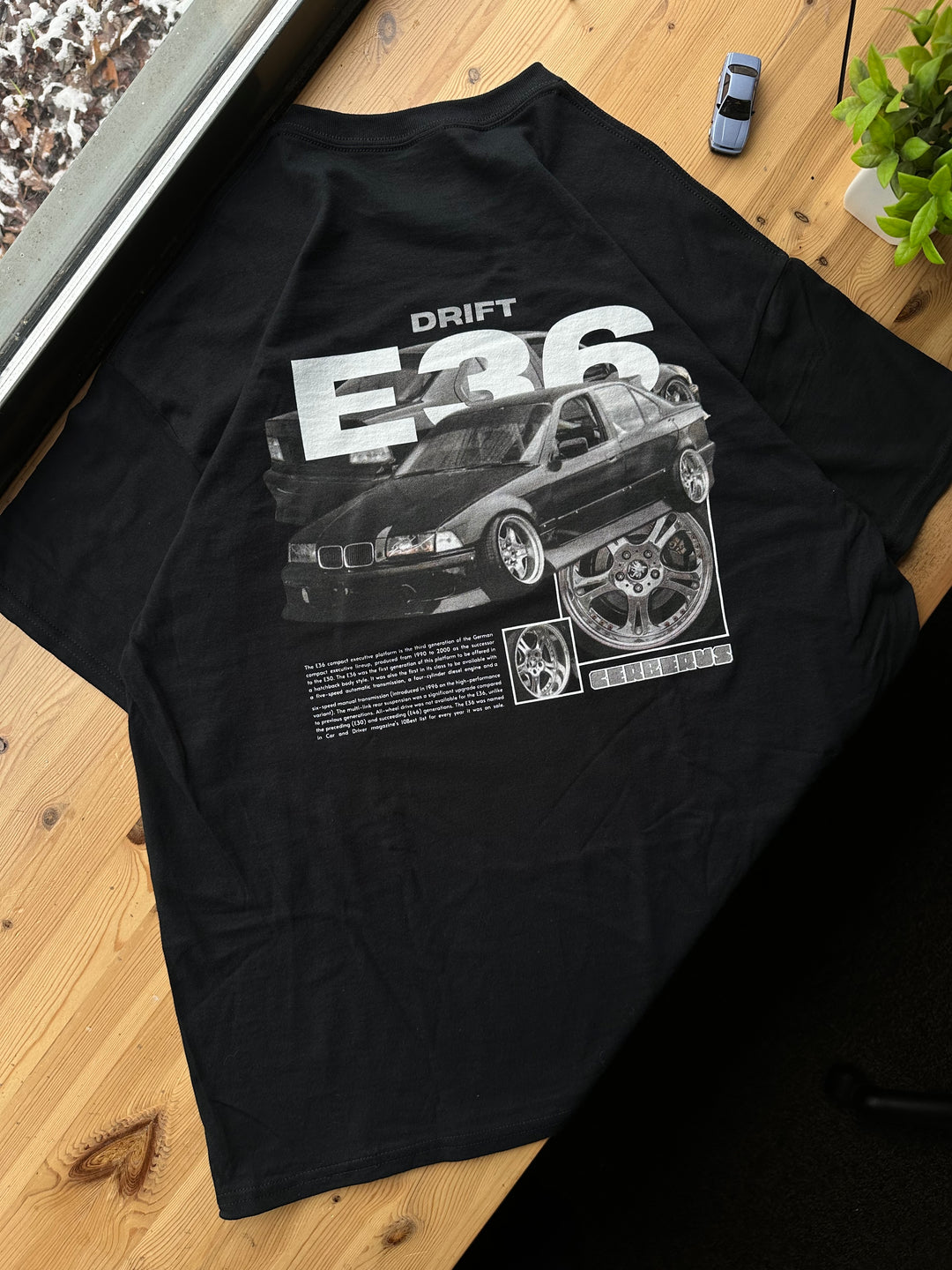 Black T-shirt with Bmw E36 graphic on the back, picture of the rear, T-shirt on desk